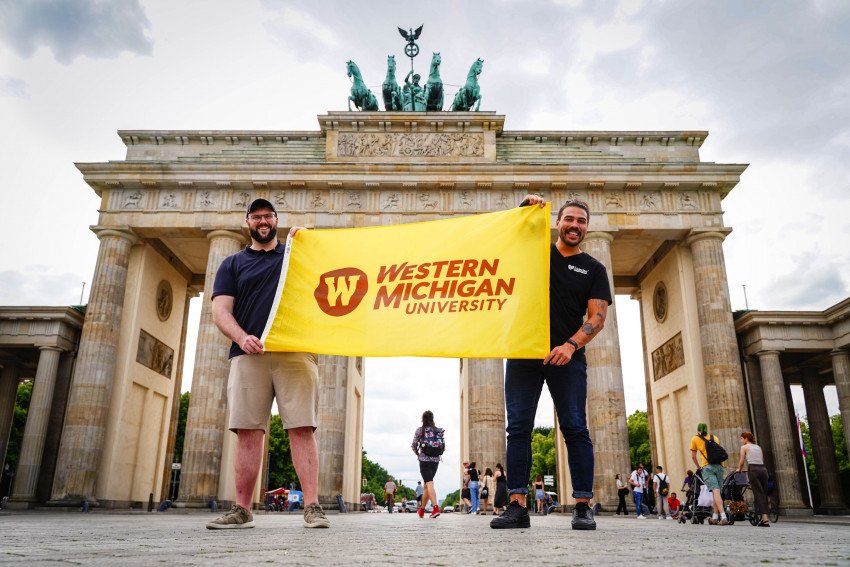 Two students hold a WMU flag in Berlin.