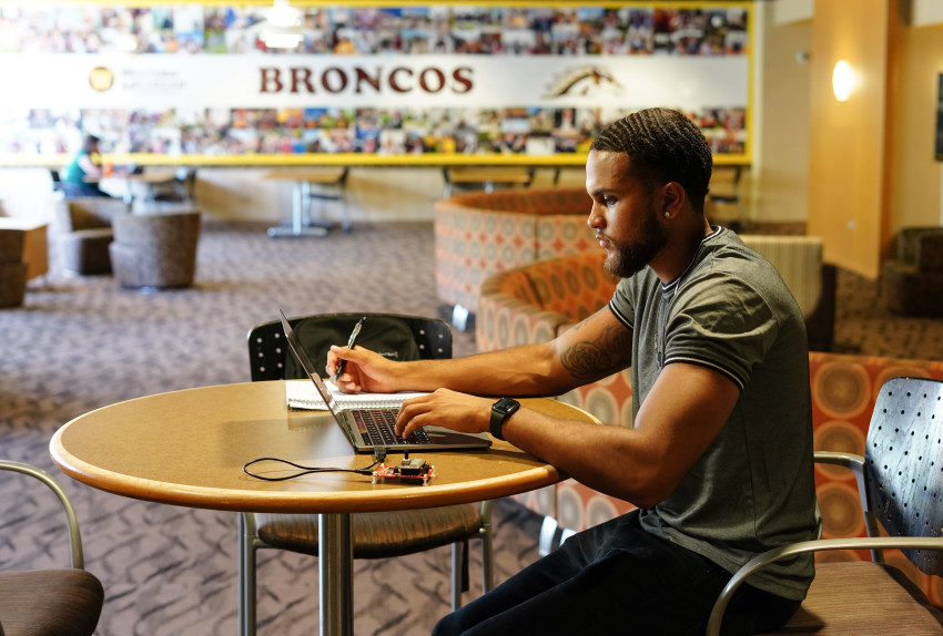A student working on a laptop in the Bernhard Center.