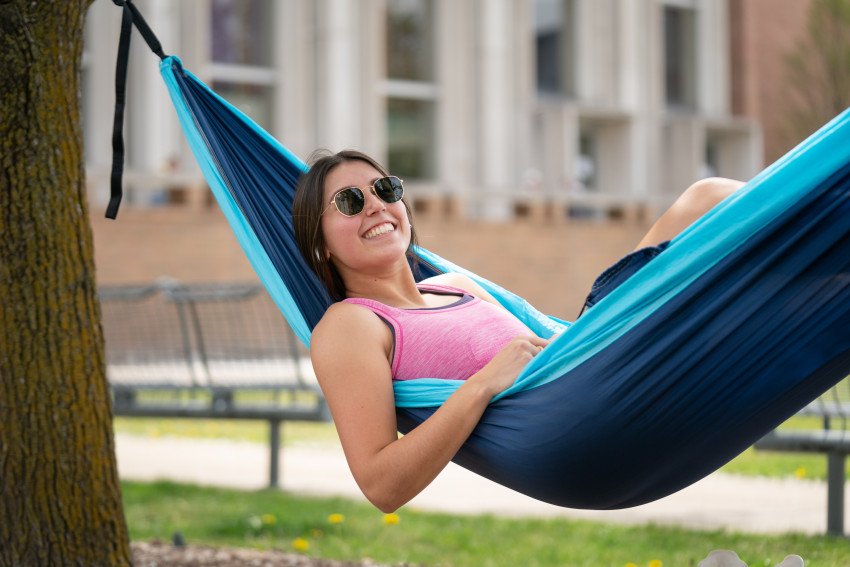 A student relaxing in a hammock.