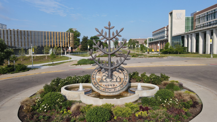 The seal sculpture on WMU's campus with Sangren Hall and the new student center.
