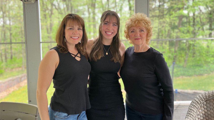 A portrait of Ann Parmeter-Cripps, Audrey Cripps and Janice Parmeter. All are wearing black shirts, and the background of the photo is a wooded setting.