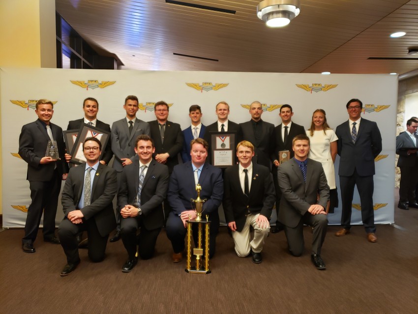 Photo of the 2019 Sky Bronco flight team posing with a trophy and various plaques.