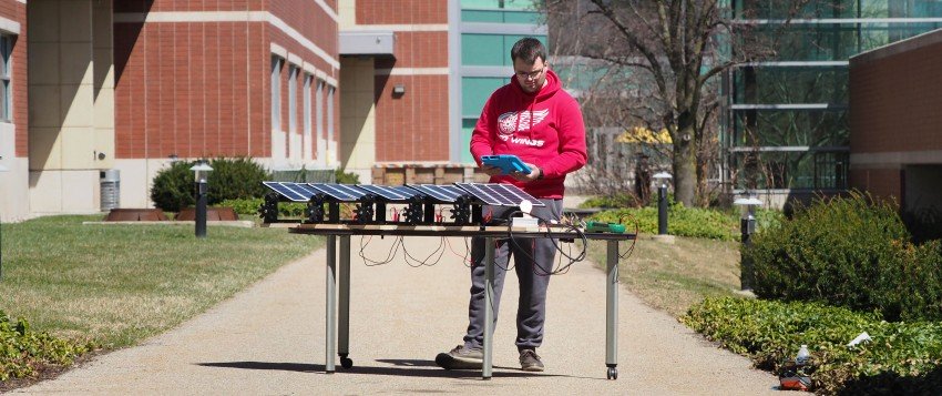 Photo of WMU student Steven Spannagel operating a scaled-down solar panel.