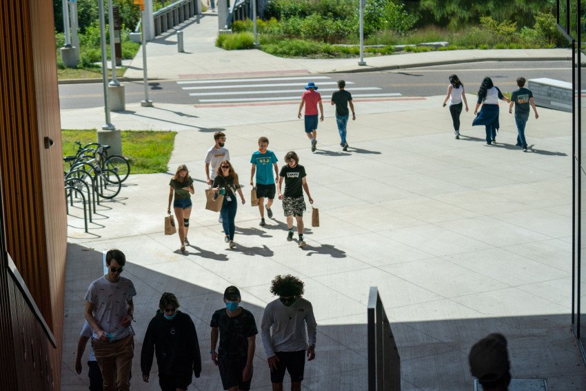 Students walking on a patio and up steps.