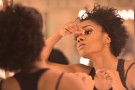 Woman putting on makeup in the mirror before a performance.