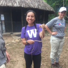 Female WMU student smiles while holding a snake in Belize.