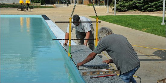 Photo of workers placing granite on WMU Campus Fountain.